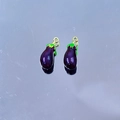 Detailed view of two eggplant-shaped enamel charms with purple finish and green leaves - Eggplant #1