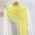 Bright yellow crinkled cotton scarf for women shown on a wooden hanger with fringe edge - Bright Yellow