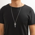 Détail du collier avec pendentif croix tête de lion argenté porté par un modèle homme - Animal couronné