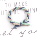 Detail of hand-woven green blue and beige braided hair tie on a white display card - Neon Green-Royal Blue
