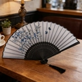 Classic folding fan with blue floral patterns, black bamboo ribs and a silk tassel - Blue Flower Butterfly Black Rib