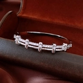 Vue macro d'un bracelet en métal argenté avec pavé de zircons sur support en cuir sombre - Bracelet Plaqué Or Réel 18K / Argent