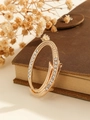 Elegant rose gold oval brooch with sparkling rhinestones on a vintage leather book - Gold Letter O