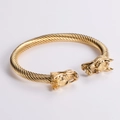 Detailed view of golden twisted cable bracelet featuring intricately carved dragon heads - Gold Cable Gold Dragon Head