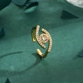 Bague Oeil Maléfique dorée avec cristaux étincelants sur fond vert texturé - Ouvert Réglable / Doré