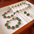 Close-up of emerald jewelry set with necklace and bracelet in a white velvet box - Emerald Green Gemstone Jewelry Set (Round Flower)