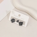 Parure de boucles d'oreilles fleurs en acier noir et zircons sur carte de présentation - Marguerite Noir