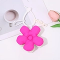 Detailed view of a pink fabric floral keychain with a white plastic chain on a desk - Rose Red and White
