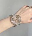 Macro view of wide silver metal bracelet with a minimalist concentric spiral design - Silver Multi-Layer Spiral Line Style (D1466)
