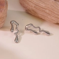 Macro detail of silver liquid metal lava earrings on textured natural stone base - Silver