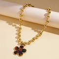 Dettaglio collana con perline dorate e ciondolo a fiore vintage in tartaruga e oro - Forma di Fiore a Cinque Petali (Motivo Tartarugato)