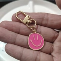 Close-up of pink enamel smiley face keychain with golden D-ring clasp and swivel - Large Single Rose Red
