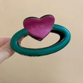 Close-up of green oval acrylic hair claw clip with a glossy pink heart accent - Pink-Green Heart Oval