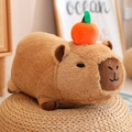 Brown capybara plush toy with an orange fruit on top seated on a woven cushion - Lying Squeaking / 30cm