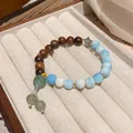 Elegant beaded bracelet with wood beads, ocean stone, green jade, and Chinese knot tassel - Blue/Gradient Beads