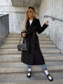 Street style view of a black mid-length wool coat with belted waist and buttoned cuffs - S / Black