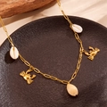 Détail du collier à maillons dorés avec breloques coquillages et crabes sur un plateau - Collier Coquillage Crabe(H704)