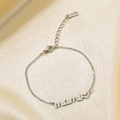 Detailed view of silver stainless steel mami bracelet with heart charm on gold silk cloth - Steel Color Bracelet (KB182676-KLX)