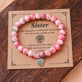 Pink and green floral beaded bracelet with a metal heart charm on a gift card - Pink White Green Metal Heart Card Bracelet