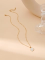 Detail of gold sunburst pendant with white enamel on a delicate sequin link chain - Sun