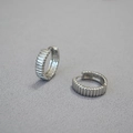 Macro di orecchini a cerchio in ottone argentato con creste verticali su tessuto grigio - Argento
