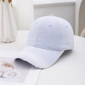 Close-up of distressed brim on a vintage washed light blue denim baseball cap - Blue