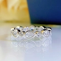 Elegant pear-shaped and round silver ring with white stones on a reflective surface - US 7 / White Gold