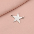 Colgante de estrella de acero inoxidable plateado con doble agujero sobre tela rosa con textura - Color Acero