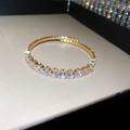 Close-up of golden tennis bracelet featuring shimmering round-cut cubic zirconia stones - Gold-Round
