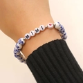 Dettaglio del braccialetto elastico in ceramica con perle floreali blu e ciondoli MIMI - Stile Lettera MIMI (F38)
