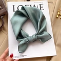 Green silk square scarf tied in a bow on a Loewe magazine for an elegant chic look - Sea Green