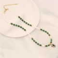 Green stone and pearl necklace with golden flower eye pendant on white display tray - Malachite