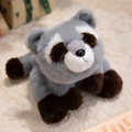 Plush raccoon stuffed animal in grey and brown tones, lying in a cozy flat position - Raccoon