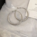 Detailed view of silver geometric C-shape hoop earrings on a white aesthetic cloth - Large Silver Hoop (41#)