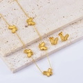 Golden double-sided embossed butterfly necklace and earrings set on stone display - 2-Piece Necklace & Earrings Set
