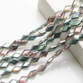 Macro view of multi-faceted emerald green crystal glass beads with iridescent coating - Rose Red Green