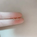 Minimalist 925 silver stud earrings featuring hollow four-leaf clover design on finger - Hollow Flower / Silver