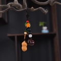 Macro detail of sandalwood peanut and persimmon pendants on a vintage wooden branch - Good Things Happen Phone Chain Type 2