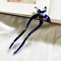 Blue tortoiseshell acetate U-shaped hair pin with star design on an art book - Blue