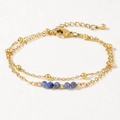 Detail of a double-layered gold chain bracelet with blue semi-precious beads and lobster clasp - Blue/Lapis Lazuli