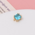 Macro view of square blue crystal pendant with gold setting and hanging loop detail - Lake Blue