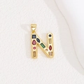 Detailed close-up of a golden letter N pendant featuring vibrant multi-color gemstones - Letter N