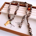 Detail der Halskette aus Leopardenstoff mit Holzperlen und goldenem Fisch-Anhänger - Gold Leopard Muster