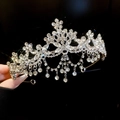 Detail of silver floral crown with sparkling rhinestones and elegant tassels held by hand - Tassel Teardrop Tiara / Silver