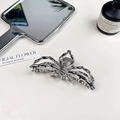 Macro detail of silver metal spider hair claw clip with sleek industrial punk aesthetic - Silver