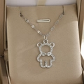Gros plan d'un pendentif ours en argent serti de zircons avec détail de nœud - Ours