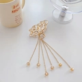 Elegant gold butterfly hair claw clip with long pearl tassels shown on a white tabletop - Model J Gold 8cm