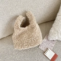 Gros plan sur la texture moelleuse en laine d'agneau d'un sac cabas beige minimaliste - Khaki