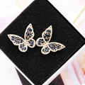 Macro view of butterfly earrings with blue crystals and gold-plated frames - 14K Gold Blue Zirconia