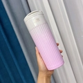 Pink gradient stainless steel travel coffee mug with textured grip shown in hand - 500ml / Pink